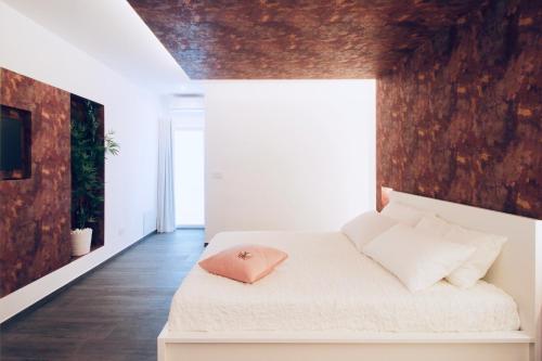 1 dormitorio con 1 cama blanca y suelo de madera en B&B Butterfly Suite, en Bitritto