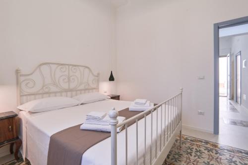 a bedroom with a white bed with towels on it at Casa dei Nonni in Avetrana