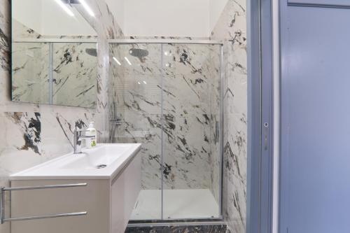 a white bathroom with a shower and a sink at Casa dei Nonni in Avetrana
