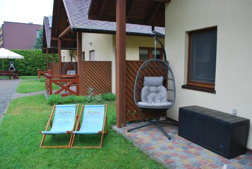 a chair sitting outside of a house with two signs at Kameleon Dźwirzyno in Dźwirzyno