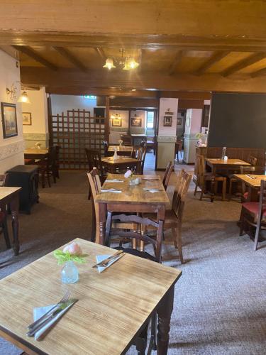 a dining room with wooden tables and chairs at The Queens Head Inn in Milton Ernest