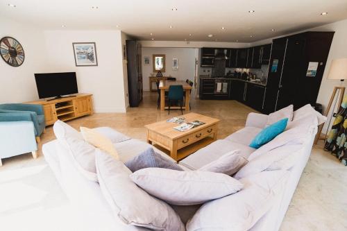 a living room with a white couch and a table at Trewhiddle Retreat V10 by Together Travel - Luxury 4-Bedroom Villa in St Austell