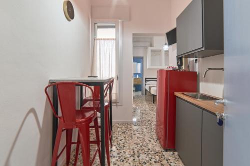 a kitchen with two red stools and a red refrigerator at Casa dei Nonni in Avetrana