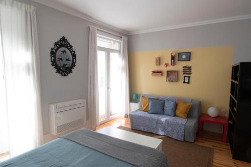 a living room with a bed and a couch at OPorto Histórico - Galerias in Porto