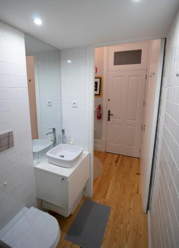 a bathroom with a toilet and a sink and a mirror at OPorto Histórico - Galerias in Porto