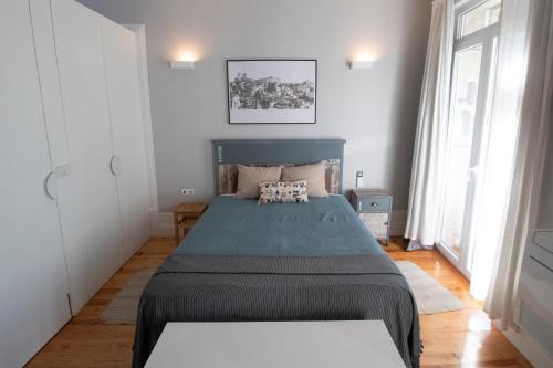 a bedroom with a bed and two windows at OPorto Histórico - Galerias in Porto