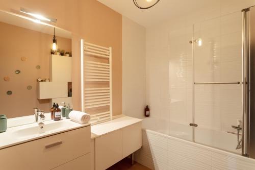 une salle de bain avec une baignoire, un lavabo et une douche dans l'établissement Le Canal - Appt avec balcon - Vue dégagée en bord de Vilaine, à Rennes