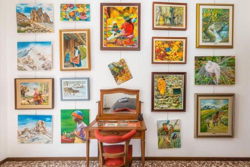 a wall full of pictures on a wall with a desk at Vivi Il Lago - Lake View in Cernobbio