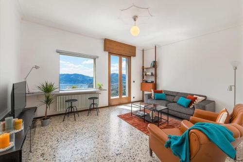 a living room with a couch and a tv at Vivi Il Lago - Lake View in Cernobbio