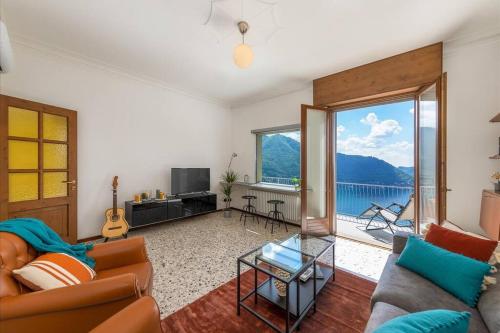 a living room with a couch and a large window at Vivi Il Lago - Lake View in Cernobbio