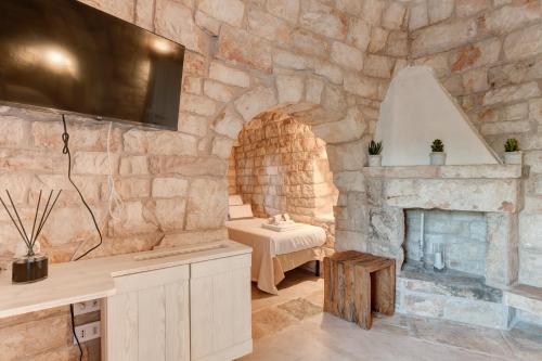 ein Zimmer mit Steinwänden und einem Kamin aus Stein in der Unterkunft APOLLO House of Puglia in Monopoli