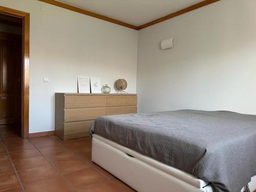 a bedroom with a bed and a wooden dresser at Aldeamento Turistico Casas da Comporta in Comporta