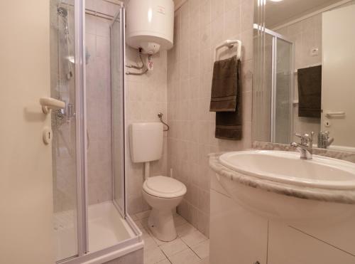 uma casa de banho com um lavatório, um WC e um chuveiro em Spring rest em Bled