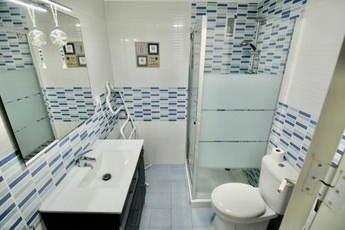 a blue and white bathroom with a toilet and a shower at Bahia de Denia in Denia