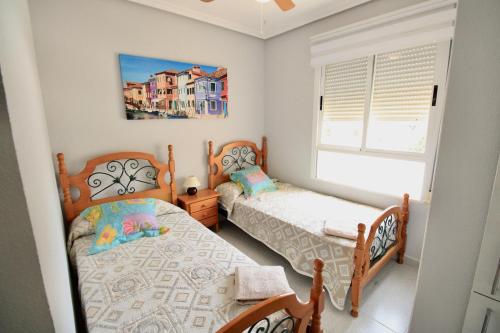 a bedroom with two twin beds and a window at Bahia de Denia in Denia