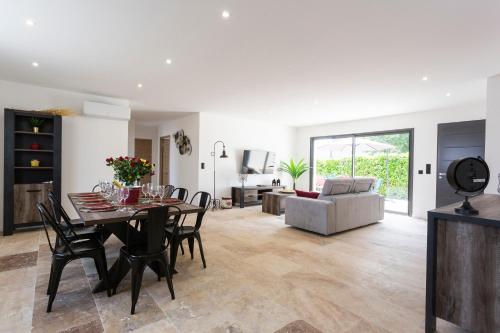 une salle à manger et un salon avec une table et des chaises dans l'établissement La Villa d'Angèle - Villa climatisée avec piscine, à Saint-Victor-la-Coste