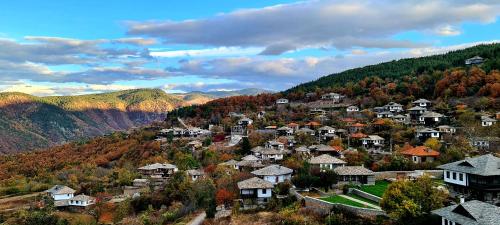 a small town in the mountains in the fall at Панорама хаус Лещен и еко къщи Дървена и Землянка in Leshten
