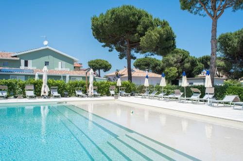 a swimming pool with chairs and umbrellas at Fiori di Cardo - Agrimare in Cervia