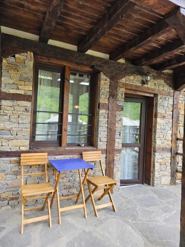 a picnic table and two chairs on a patio at Панорама хаус Лещен и еко къщи Дървена и Землянка in Leshten