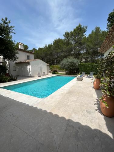 uma piscina com cadeiras e uma casa em chambre d'hôte sur le golf de pont royal em Mallemort