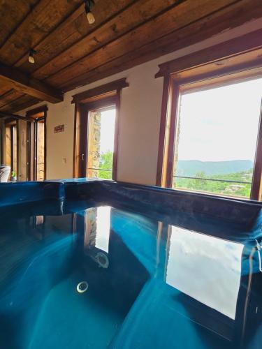 a swimming pool in a house with a large window at Панорама хаус Лещен и еко къщи Дървена и Землянка in Leshten