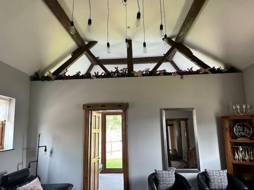 a living room with chairs and a ceiling with beams at Holmleigh Annexe in Tamworth