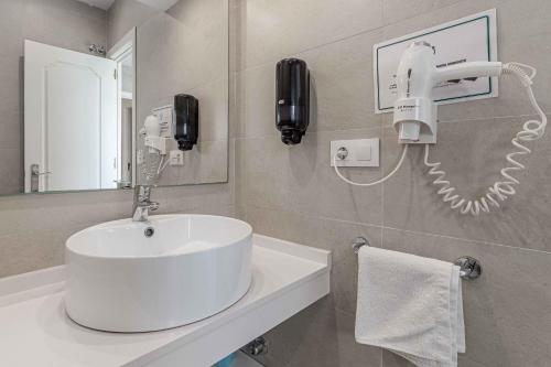 baño con lavabo y teléfono en la pared en Apartamentos Recaredo 7 , 2ª planta en Sevilla