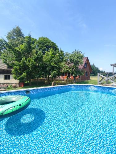 a large swimming pool with a raft in a yard at EkoStolarnia in Rutka Tartak
