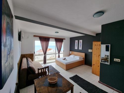 Sala de estar con sofá, cama y mesa en Apartments Adriatik, en Ulcinj