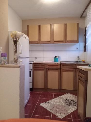 a kitchen with wooden cabinets and a white refrigerator at Zelena Oaza in Visoko