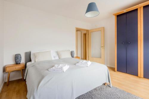 um quarto com uma grande cama branca e um closet azul em Bright and Spacious Penthouse w/ Terrace & Parking em Budapeste