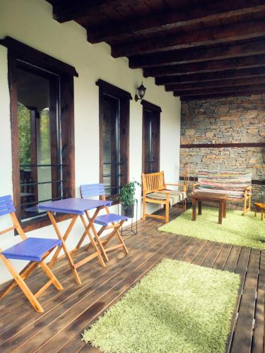 a patio with a table and chairs on a wooden deck at Панорама хаус Лещен и еко къщи Дървена и Землянка in Leshten