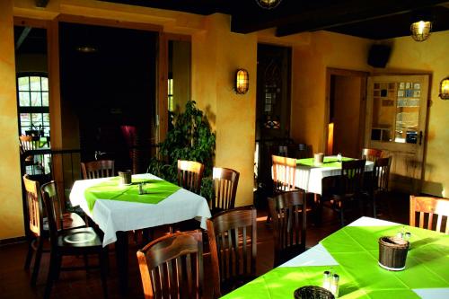 a restaurant with tables and chairs with green table cloth at Doppelzimmer 11 Gästehaus Mühlenstein in Bad Sülze