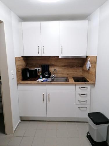a kitchen with white cabinets and a sink at Doppelzimmer 11 Gästehaus Mühlenstein in Bad Sülze