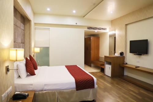 Habitación de hotel con cama y TV de pantalla plana. en Boulevard 9 Luxury Resort & Spa, en Nadiād