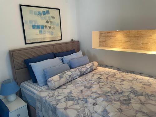 a bedroom with a bed with blue pillows at APARTMENT L.A. in Tivat