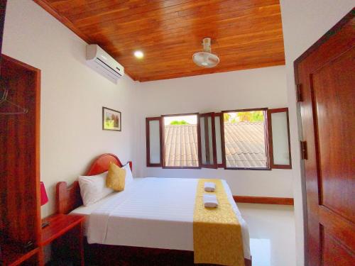 a bedroom with a bed and a wooden ceiling at Elephant Boutique Hotel in Luang Prabang