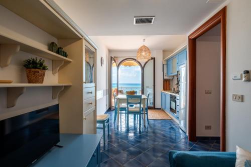 a kitchen and dining room with a view of the ocean at Residence L'Arcipelago Appartamenti Fronte Mare con Ampio Balcone in Capo dʼOrlando