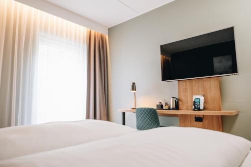 a hotel room with a bed and a flat screen tv at Go Hotel Østerport in Copenhagen