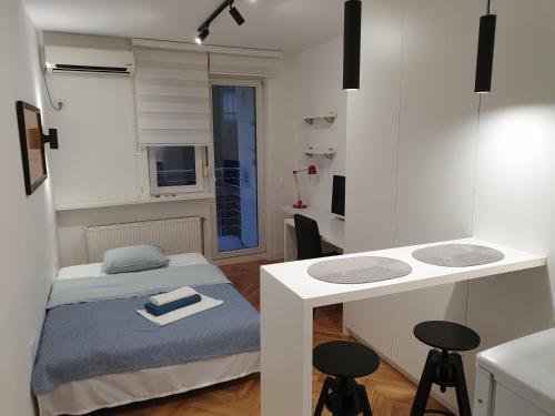 a small bedroom with a bed and a desk at Futoshka Center in Novi Sad
