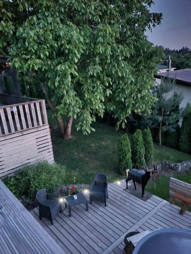 a deck with chairs and tables and a tree at ODM&A apartment in Vilnius