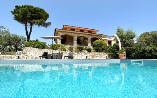 a villa with a swimming pool in front of a house at Villa Rina in Avola