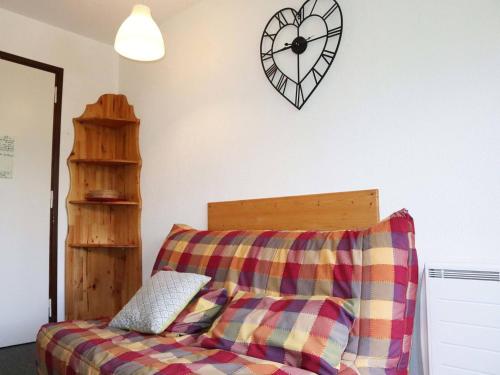 un salon avec un canapé et une horloge au mur dans l'établissement Studio 4 pers, au pied des pistes, centre station Les Orres 1650 - FR-1-322-335, aux Orres