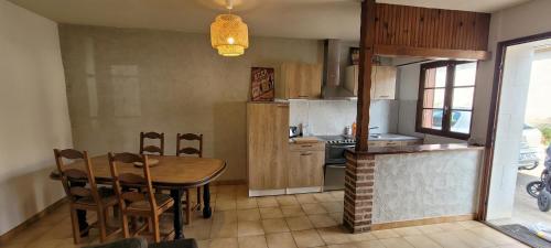 une cuisine avec une table en bois et une table et des chaises dans l'établissement Agréable Gîte proche du ZOO de Beauval et des chateaux3, à Selles-sur-Cher