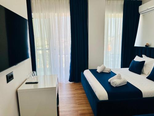 sypialnia z łóżkiem i biurkiem z ręcznikami w obiekcie ILLYRIAN hotel w mieście Ksamil