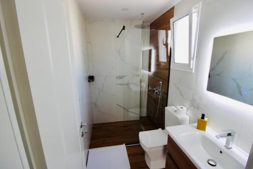 a bathroom with a toilet and a sink and a shower at ILLYRIAN hotel Ksamil in Ksamil