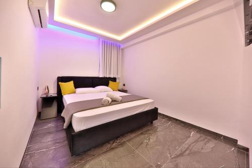 a bedroom with a bed with yellow and white pillows at חלום מול הים - סוויטת נופש יוקרתית עם ג'קוזי ונוף לים in Haifa
