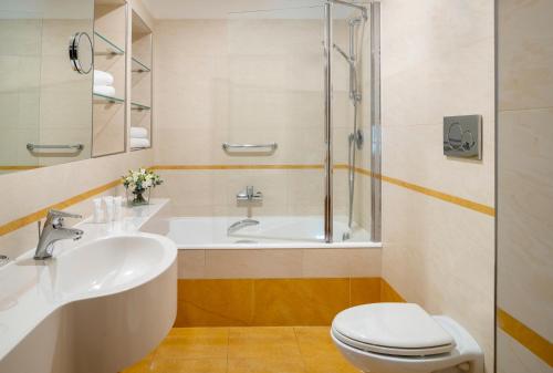La salle de bains est pourvue d'un lavabo, de toilettes et d'une baignoire. dans l'établissement UNAHOTELS Galles Milano, à Milan
