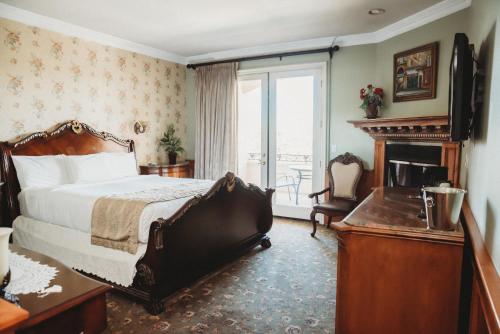 um quarto de hotel com uma cama e uma lareira em Churon Inn Winery em Temecula