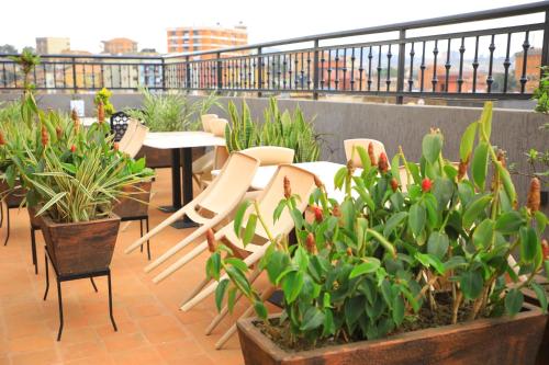 a balcony with tables and chairs and potted plants at Galaxy Motel Kampala in Kampala